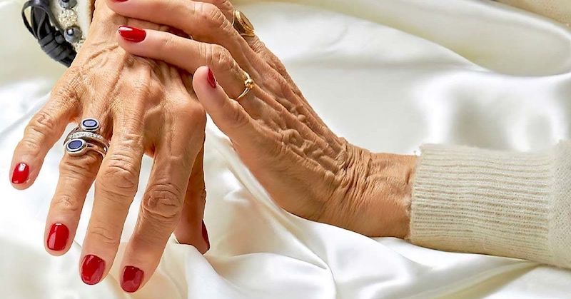 unghie con smalto rosso mani di una donna over 60