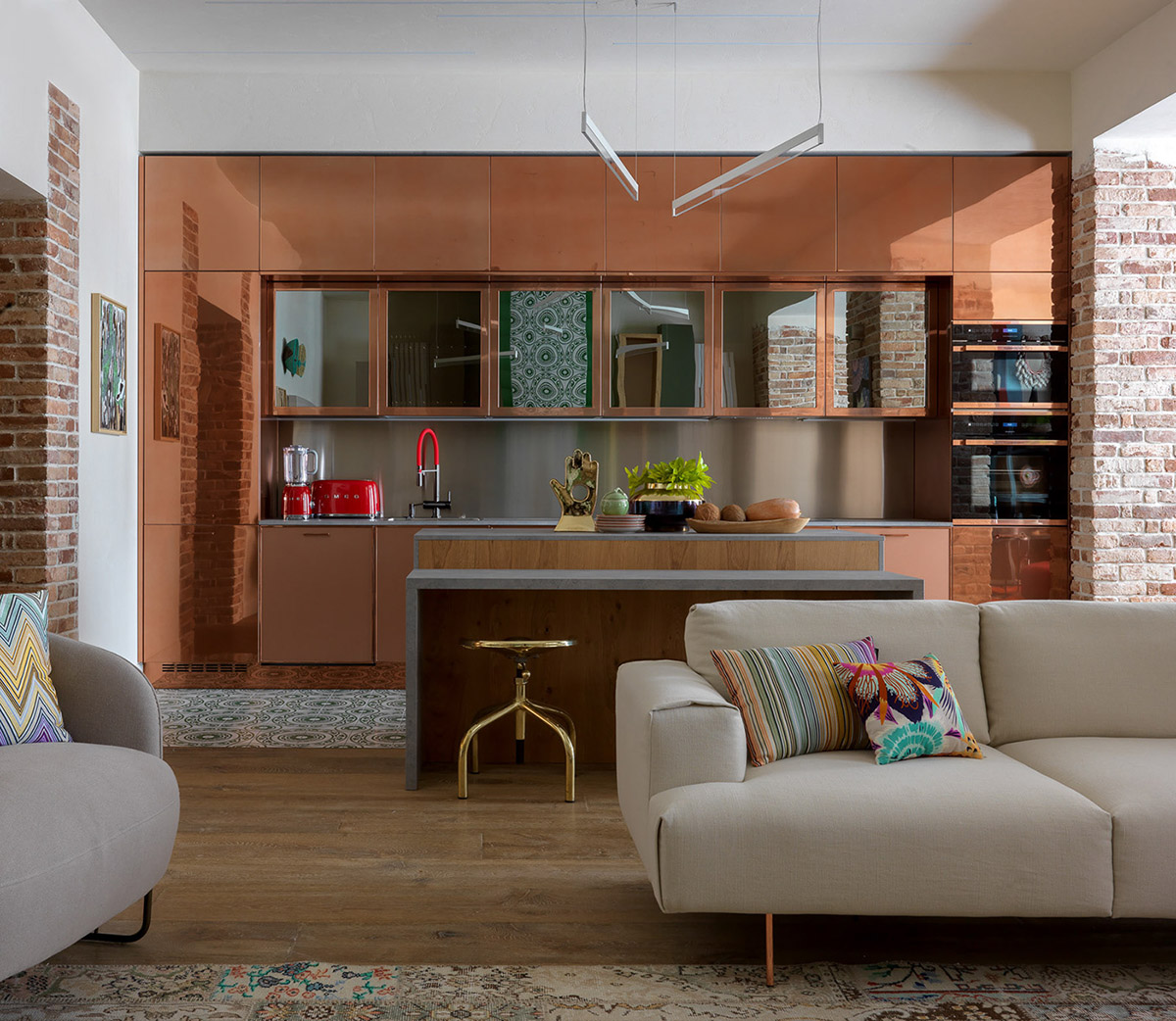 cucina color rame open space soggiorno divano grigio