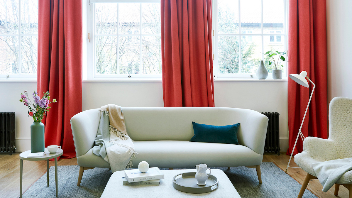 decorazione soggiorno con divano bianco tende color corallo