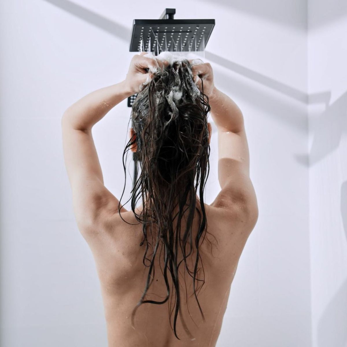 donna che si lava i capelli shampoo suolla testa
