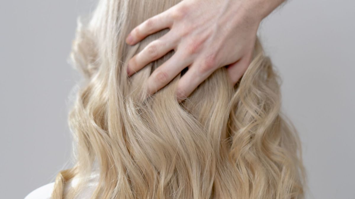 donna con capelli biondi schiariti utilizzare shampoo viola antigiallo