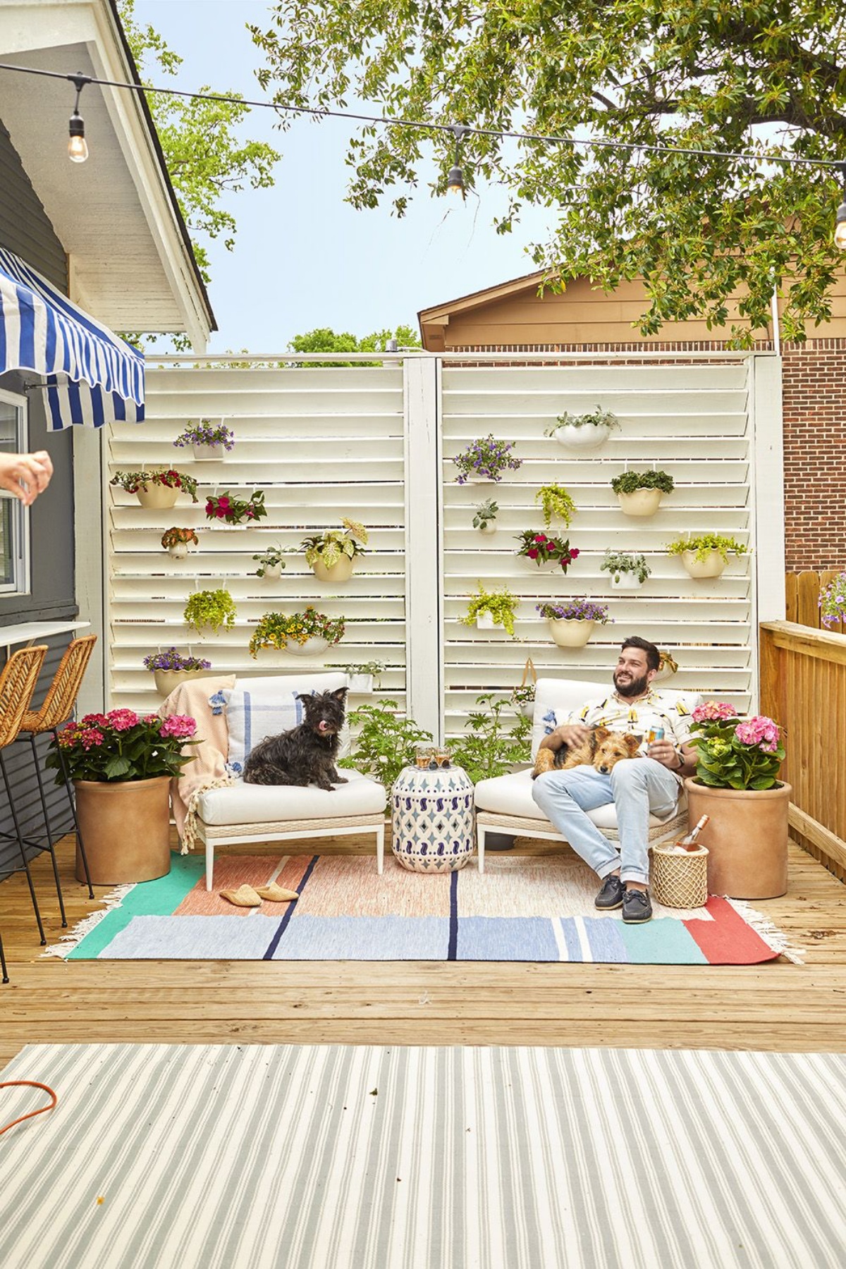patio con mobili in legno decorazione parete con vasi di piante