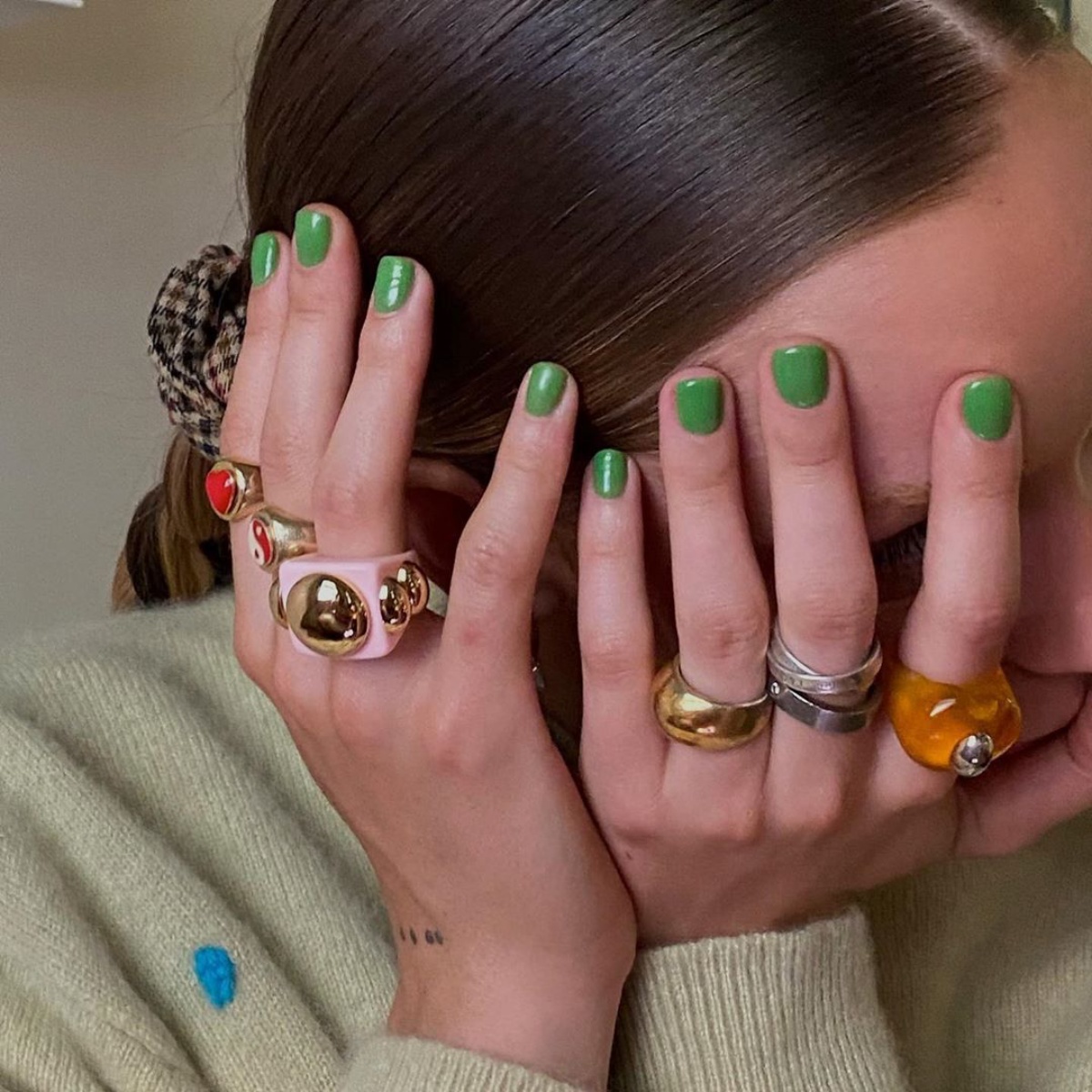 manicure con smalto verde unghie corte donna con molti anelli