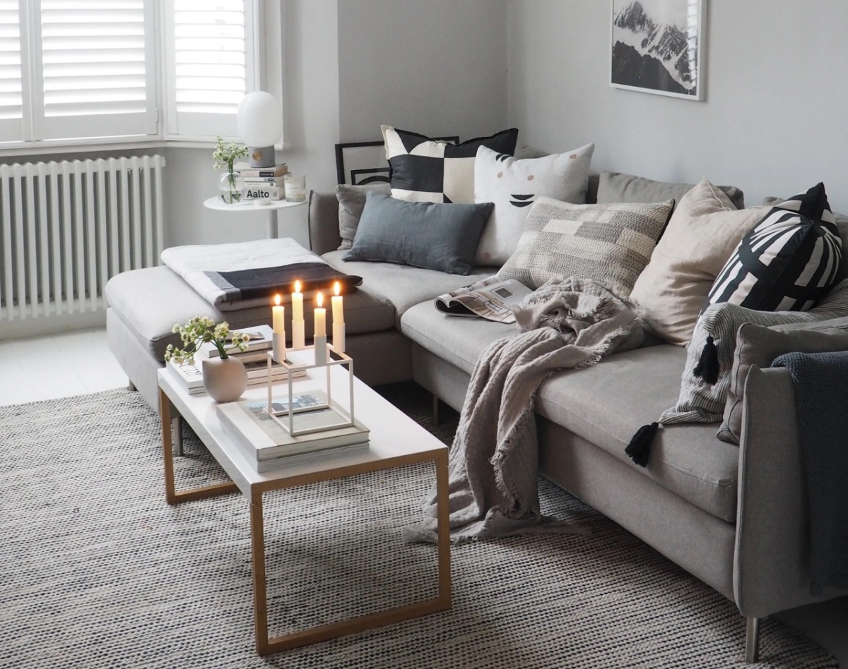 arredamento soggiorno divano grigio candele su tavolino