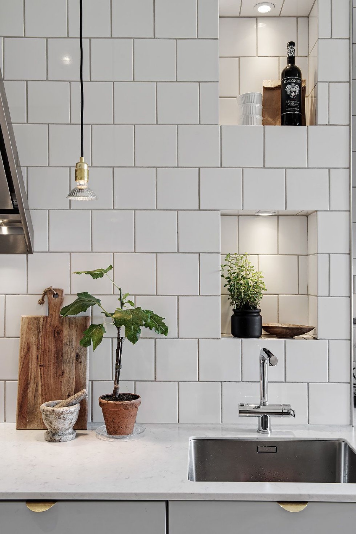 parete con piastrelle bianche cucina grigia lampada sospesa