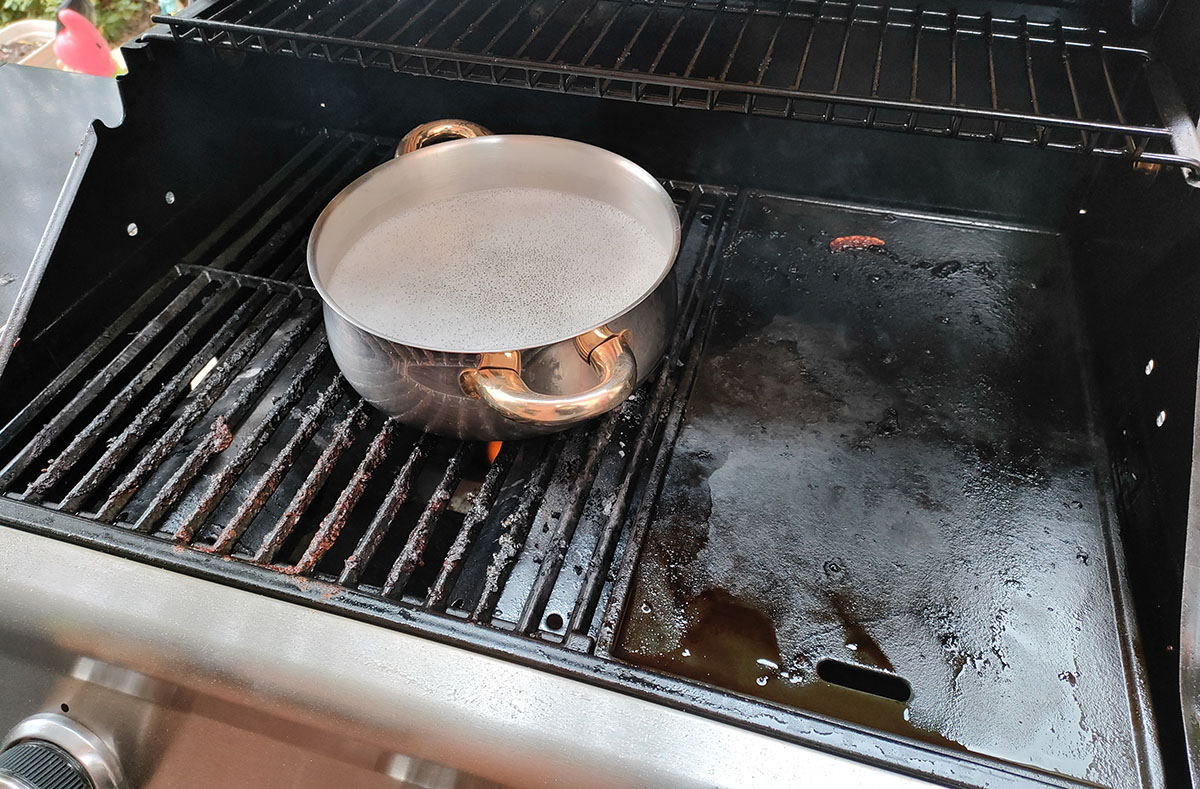 pentolino con acqua calda per pulire il barbecue