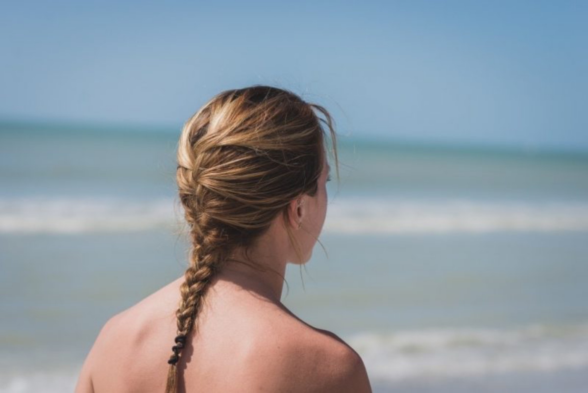 treccia sui capelli biondi capelli legati in spiaggia