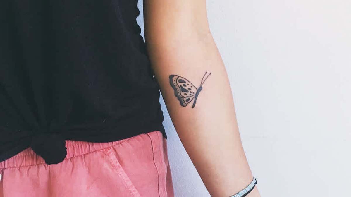 avambraccio donna con tatuaggio farfalla bianco e nero
