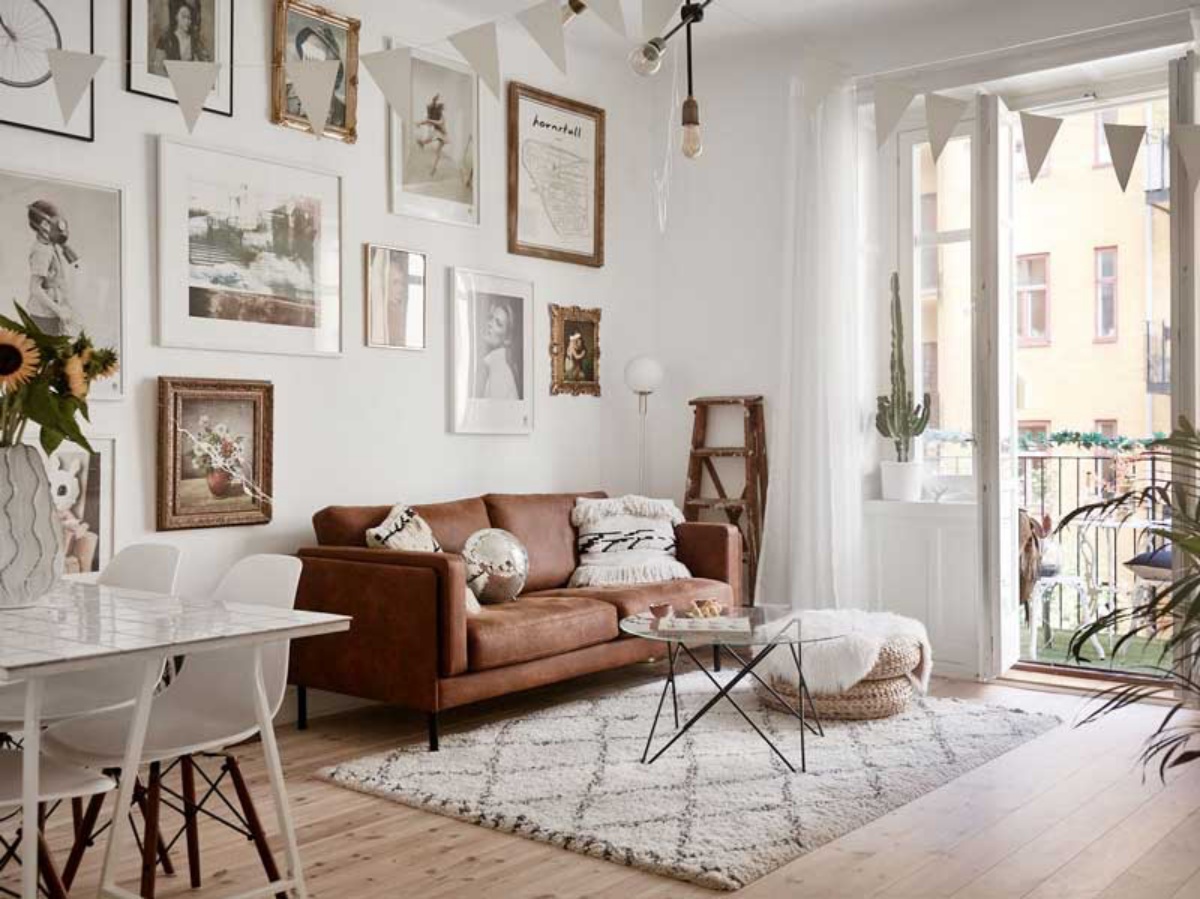 soggiorno in stile nordico divano in pelle parete con quadri