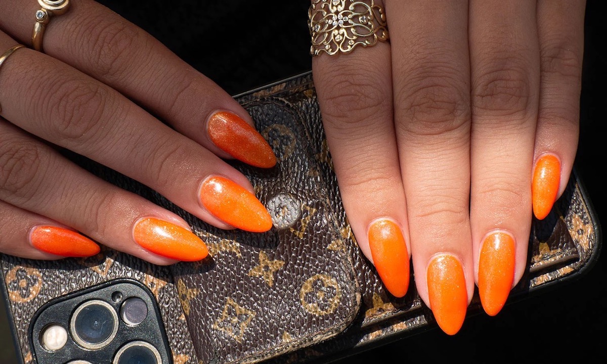 unghie stiletto smalto arancione con glitter