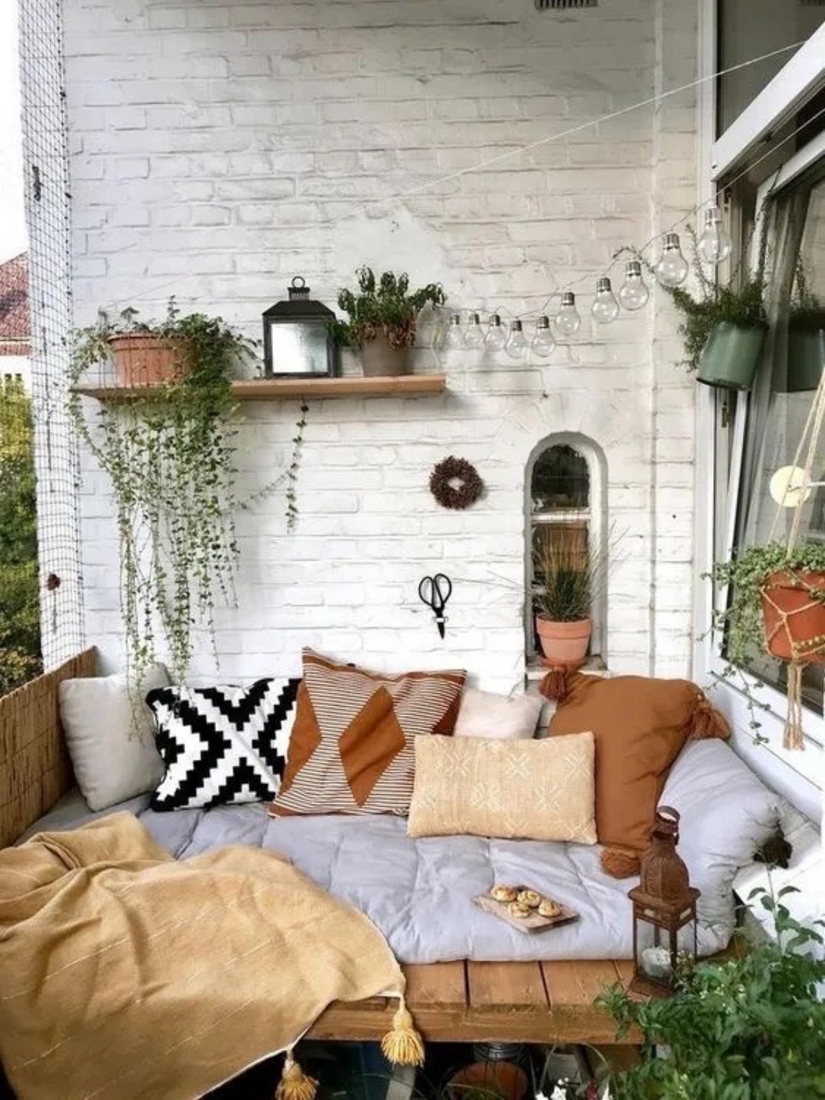 balcone con divano di pallet piante autunnali