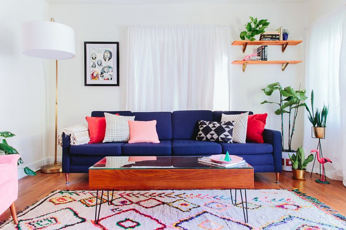 arredamento eclettico in soggiorno salotto con divano blu