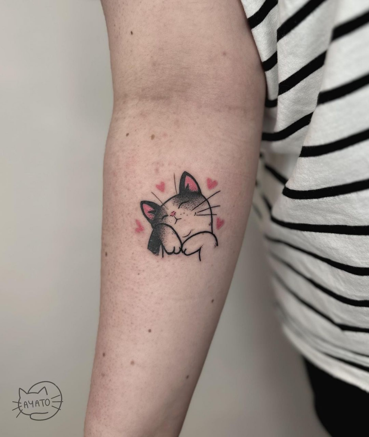 avambraccio donna con tatuaggio gattino con cuori