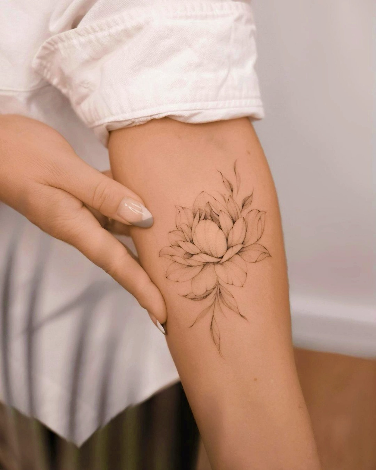 camicia bianca tatuaggio avambraccio fiore di loto