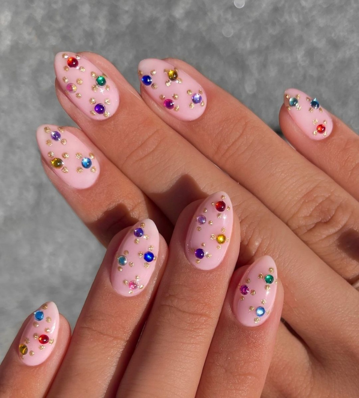 decorazione unghie con brillantini colorati su base di smalto rosa