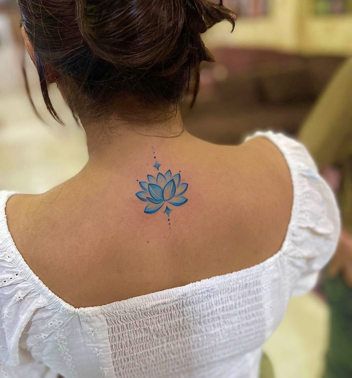 fiore di loto colorato di blu tattoo sulla schiena