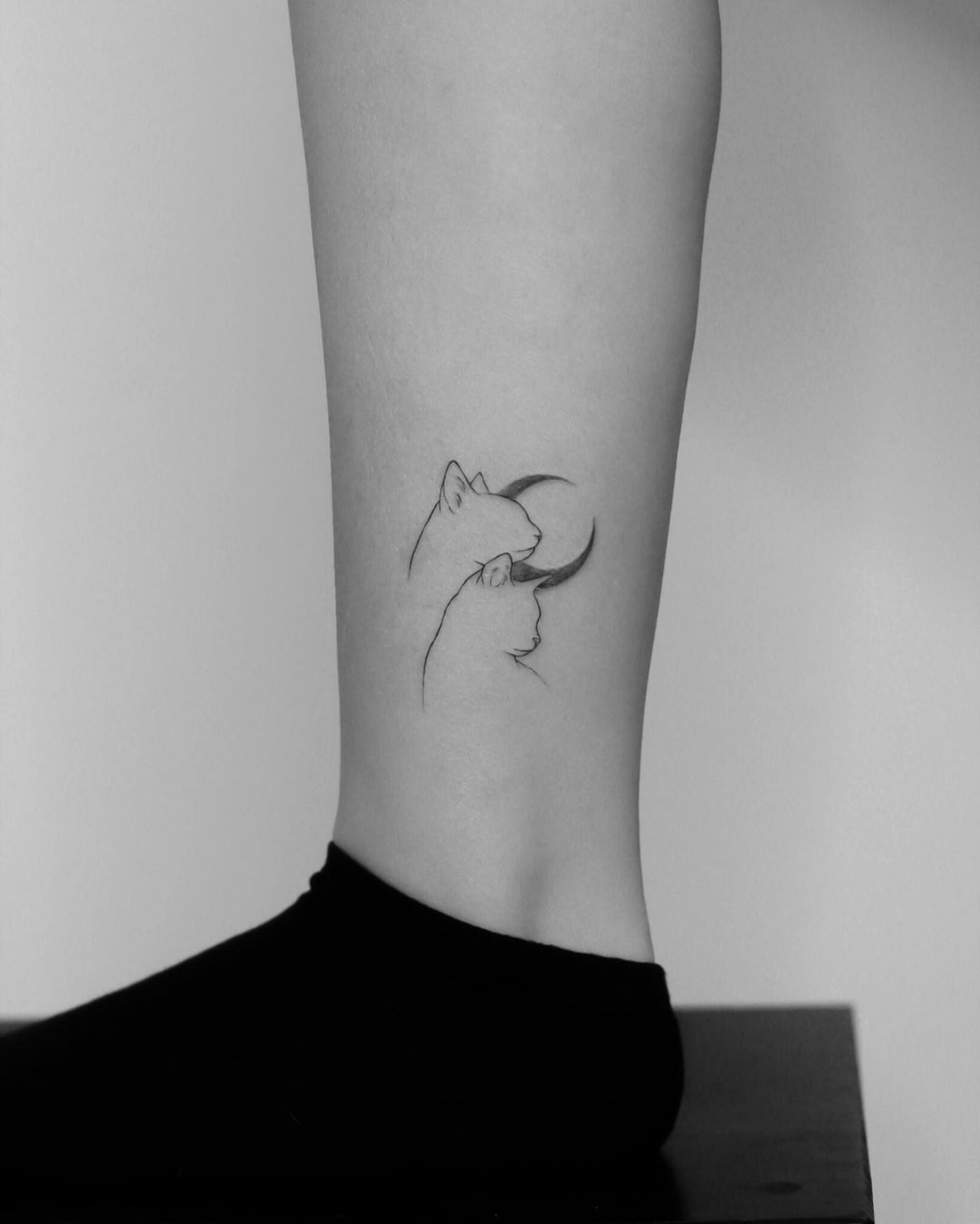 gamba donna tatuaggio sulla caviglia gatto