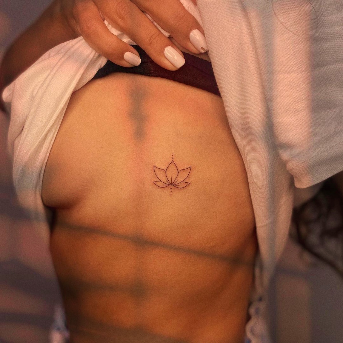 piccolo tatuaggio fiore di loto sulla pancia