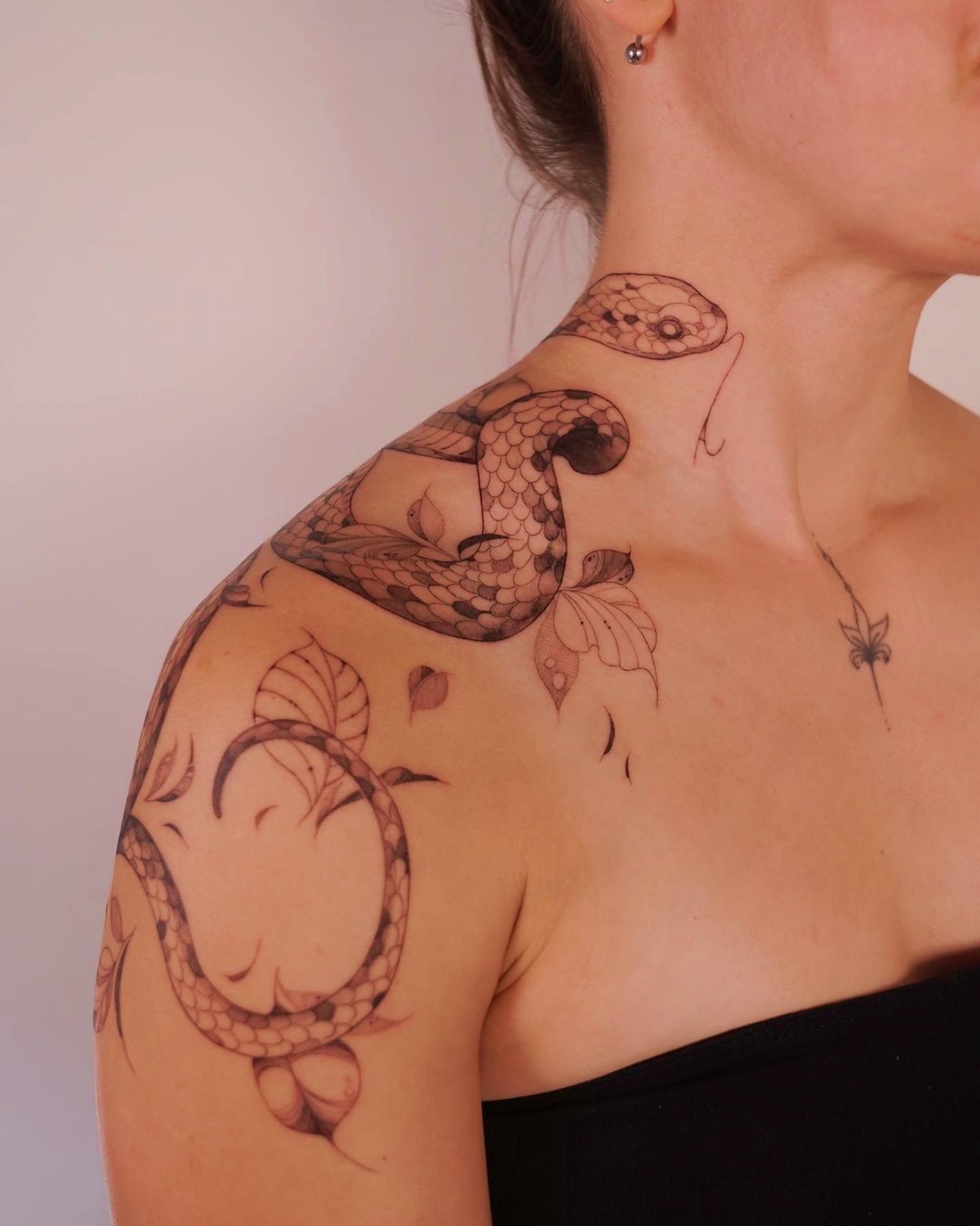 ragazza con tattoo sulla spalla disegno serpente