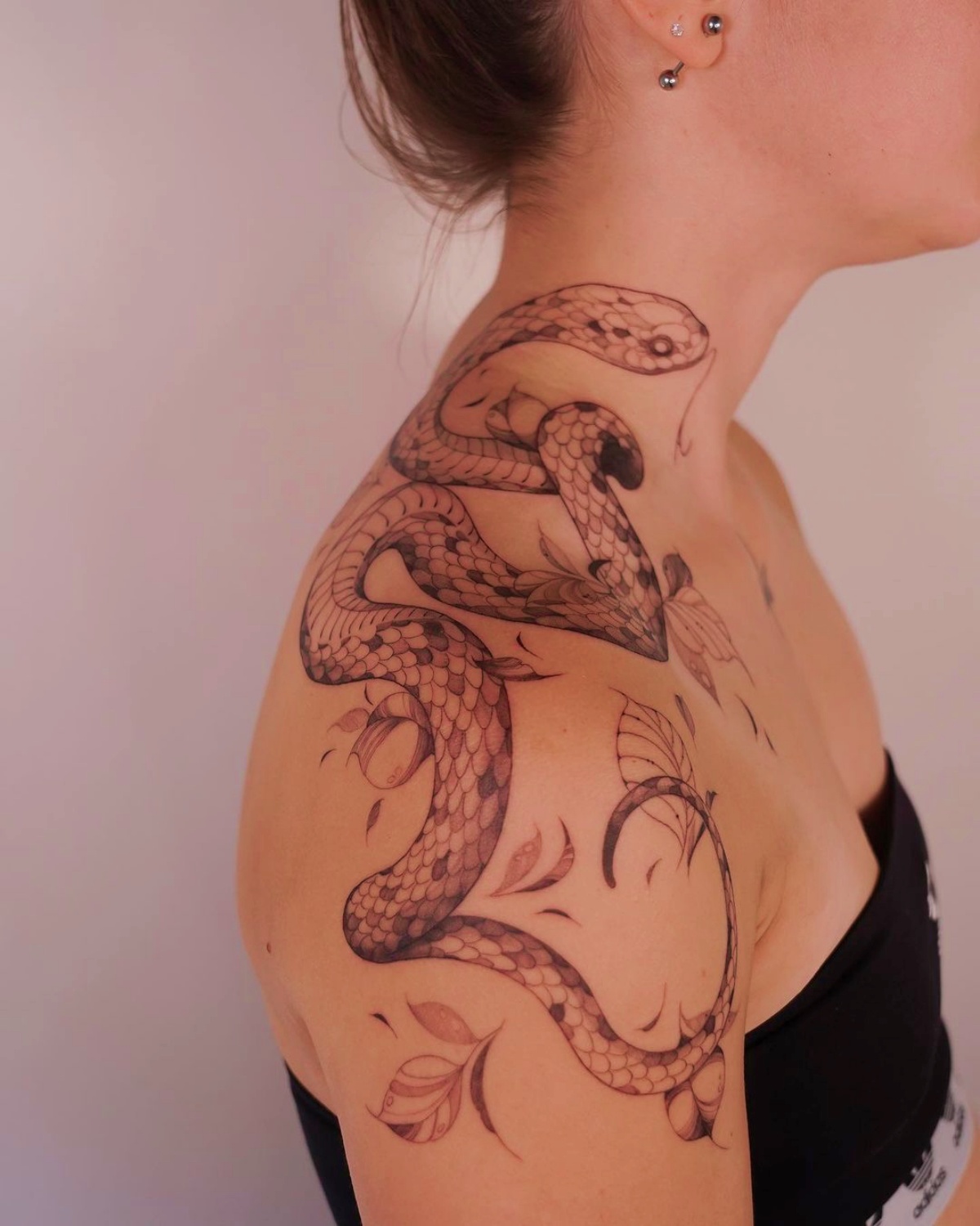 ragazza con tatuaggio sulla spalla tattoo serpente significato