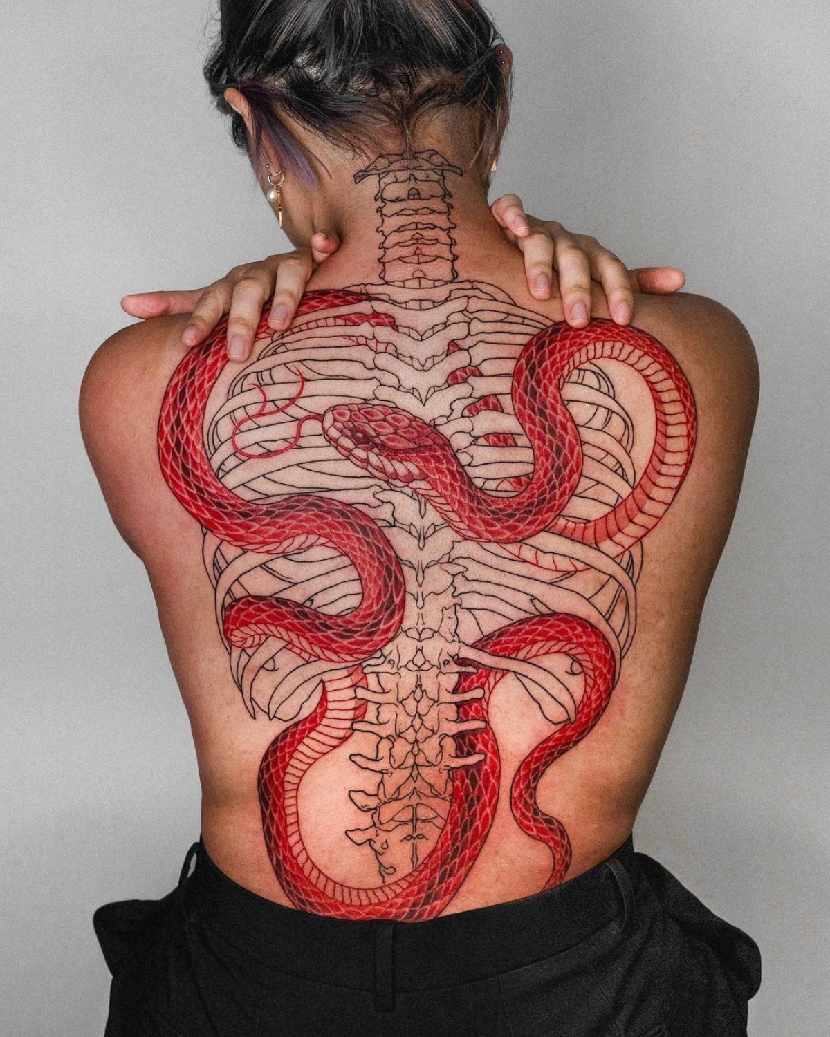 tattoo scheletro sulla schiena serpente rosso
