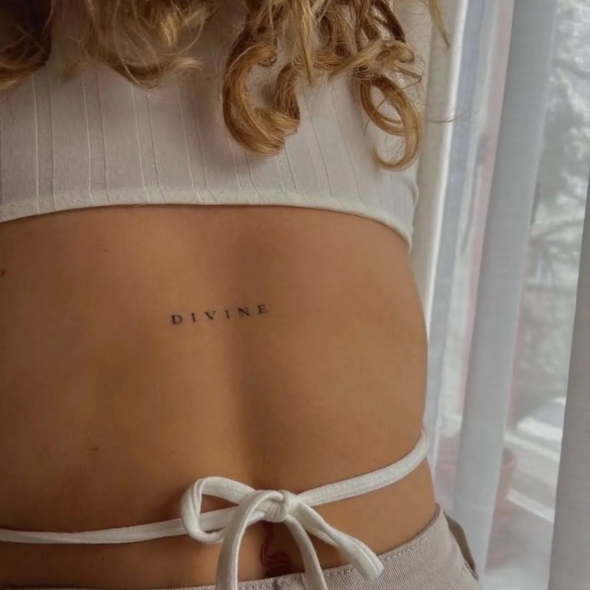 tattoo schiena donna tatuaggio piccolo con scritta divine