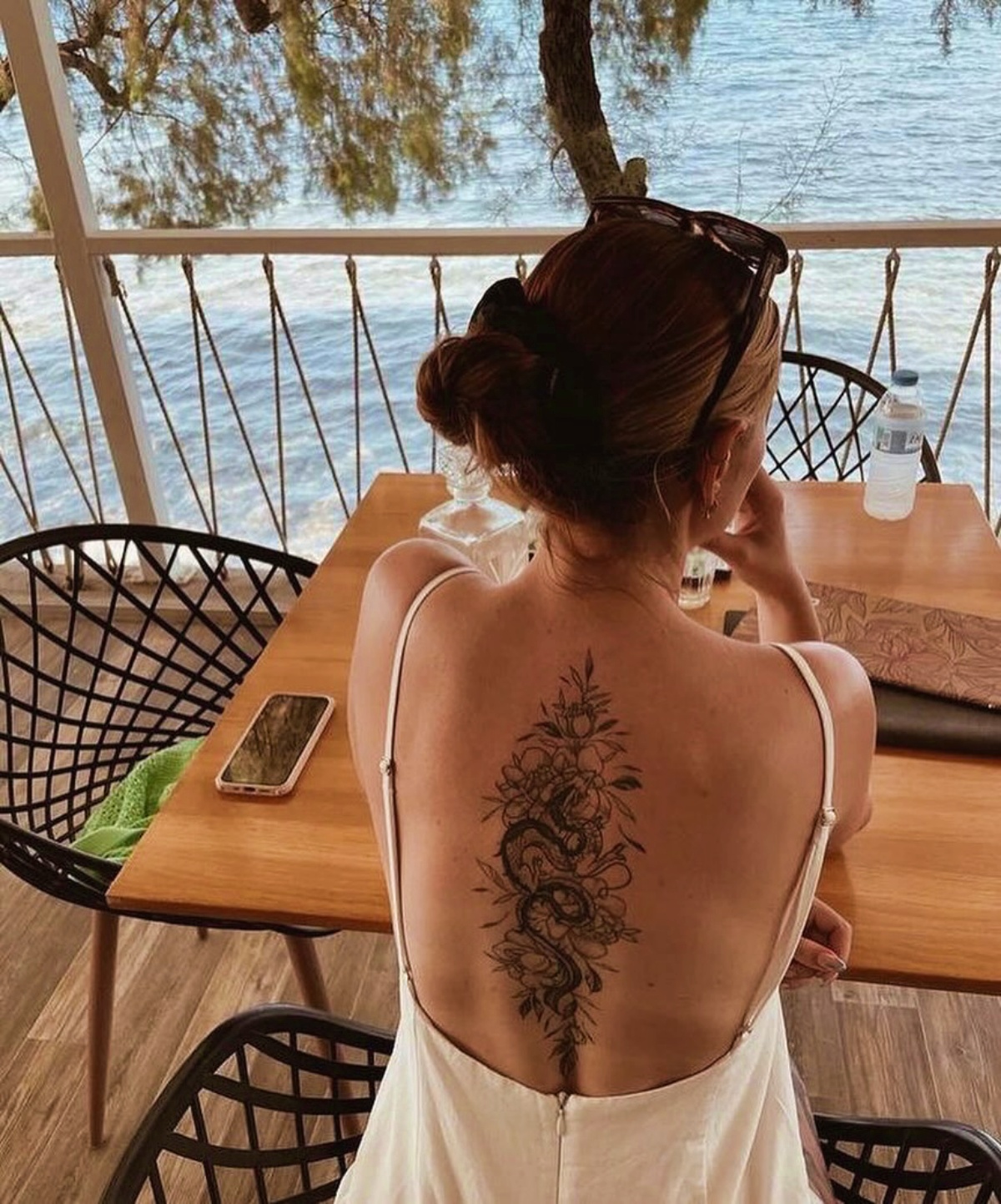 tatuaggio femminile sulla schiena serpente fiori