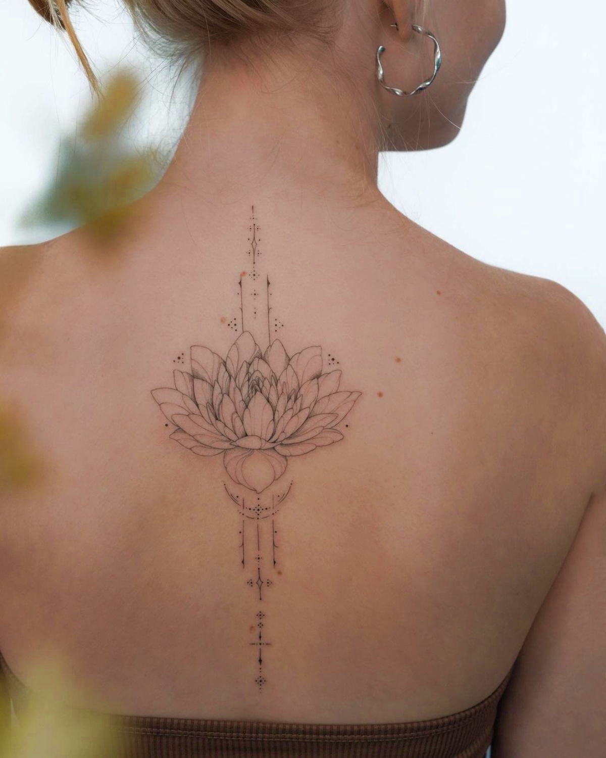 tatuaggio fiore di loto sulla schiena di una ragazza