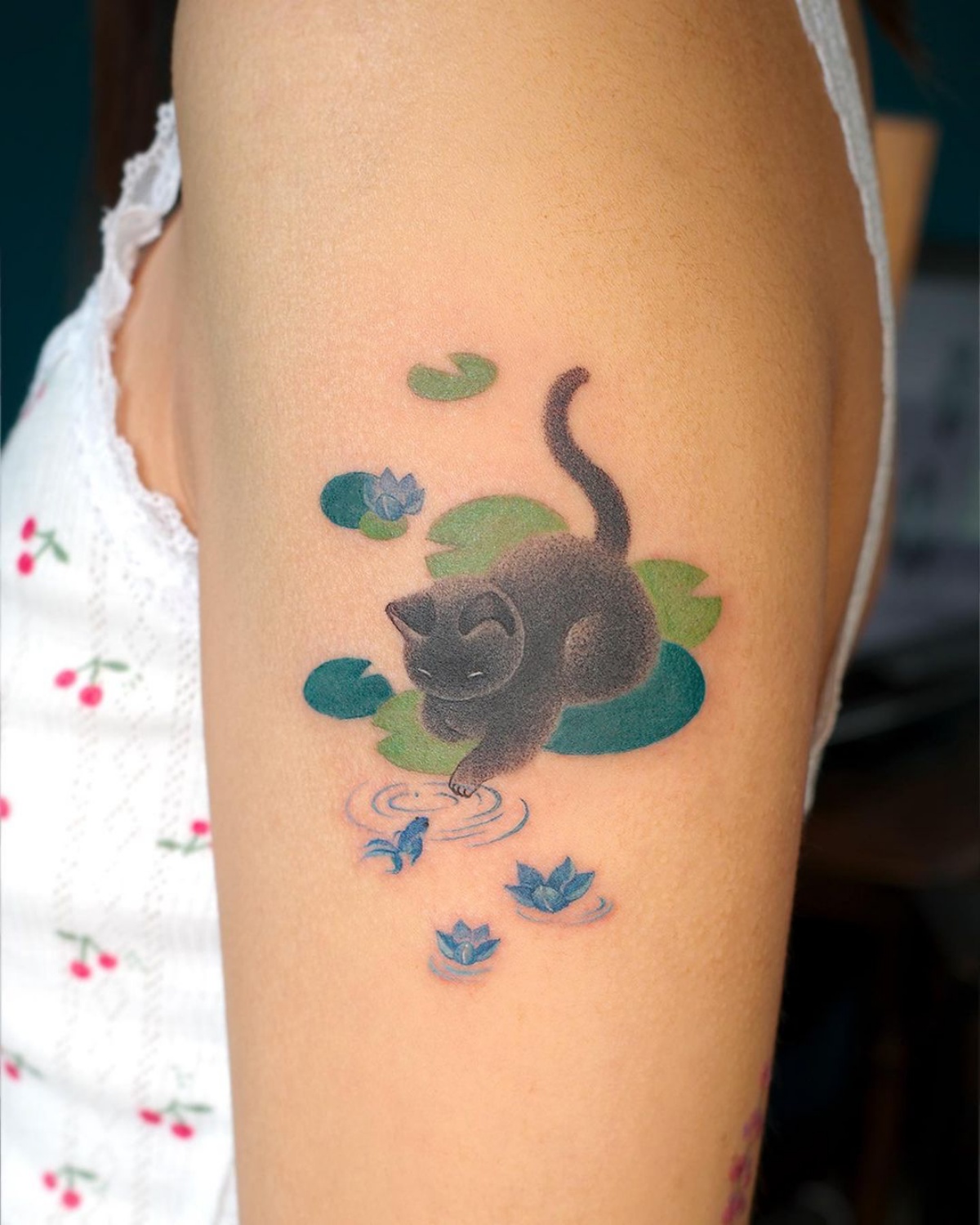 tatuaggio sul braccio di una donna disegno gattino con gioca