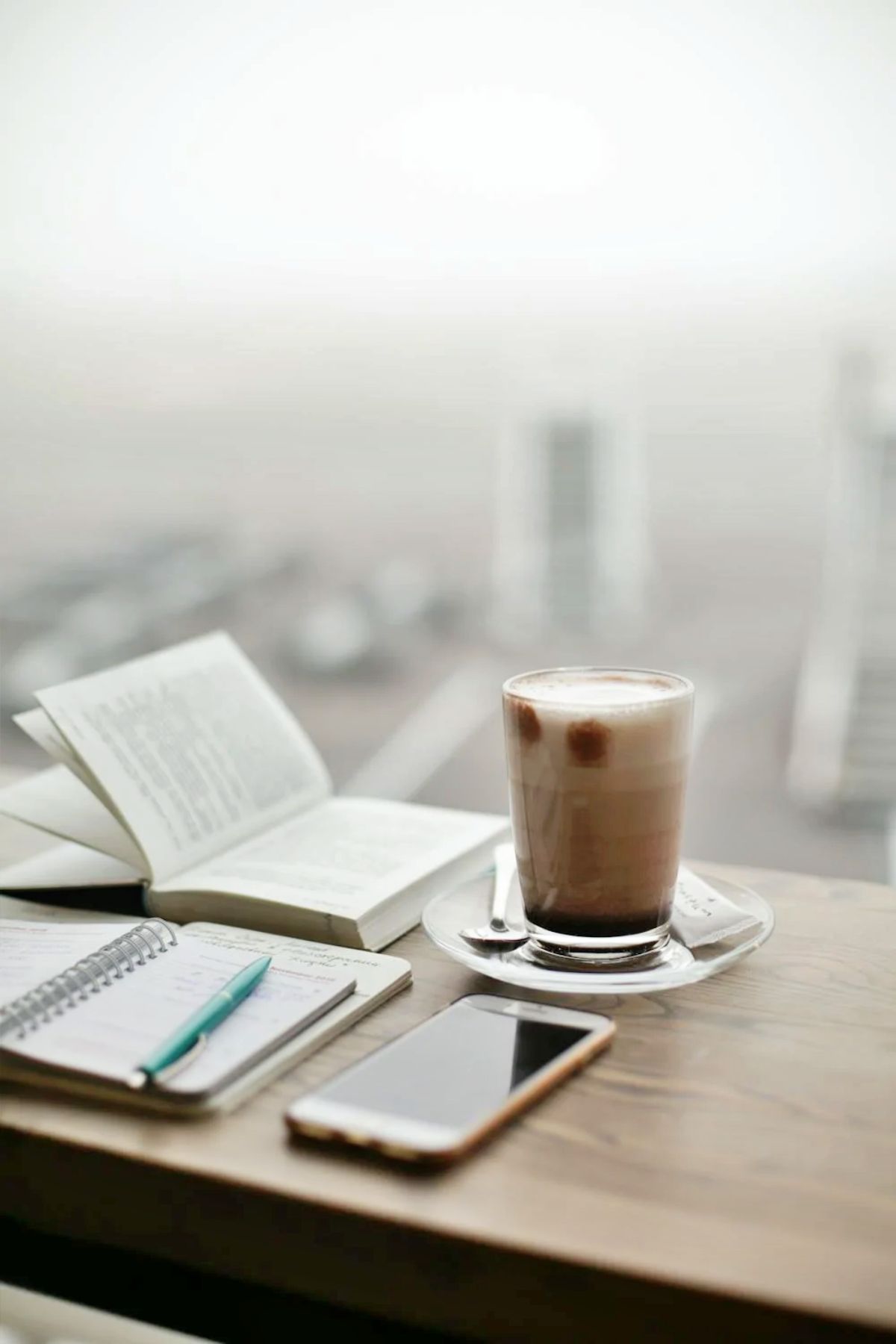 agenda personalizzata con tazza di caffè ripresa sullo sfondo di una finestra